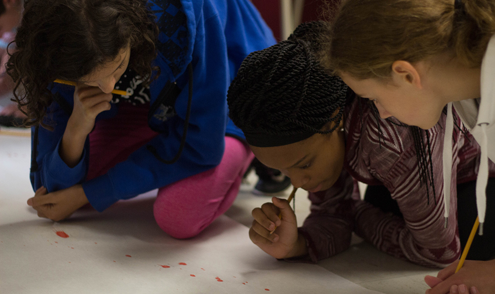 Pictured are students doing blood splatter analysis in the CSI House at Point Park.
